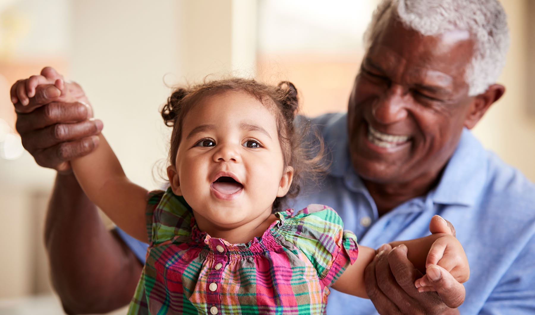 Discover Luxury Active Adult Residences in Langhorne grandfather holds baby granddaughter's hands as she stands